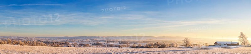 Panoramic landscape view of a rural winter landscape with farms and snowy fields on a cold winter day, Karleby, Falköping, Sweden