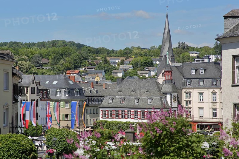 View of market square with historic town hall and twisted tower of St. Clemens church, national flags, twisted, spiral, landmark, townscape, Mayen, Vulkaneifel, Eifel, Rhineland-Palatinate, Germany
