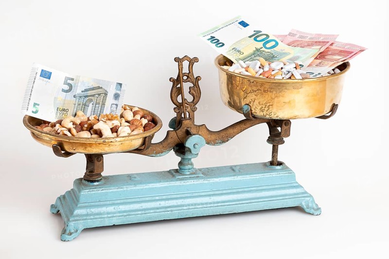 Old scales with medicines and nuts opposite, euro notes, white background