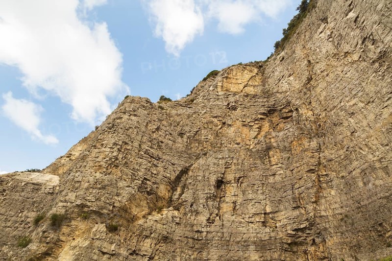 Low angle view of rugged and steep cliff with cut rock face, Sorrento, Campania region, Italy