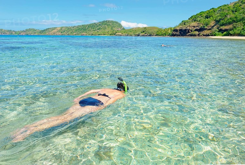 Snorkeller swimming in Fiji islands turquoise clear water, Drawaqa Island, Yasawa islands, Fiji