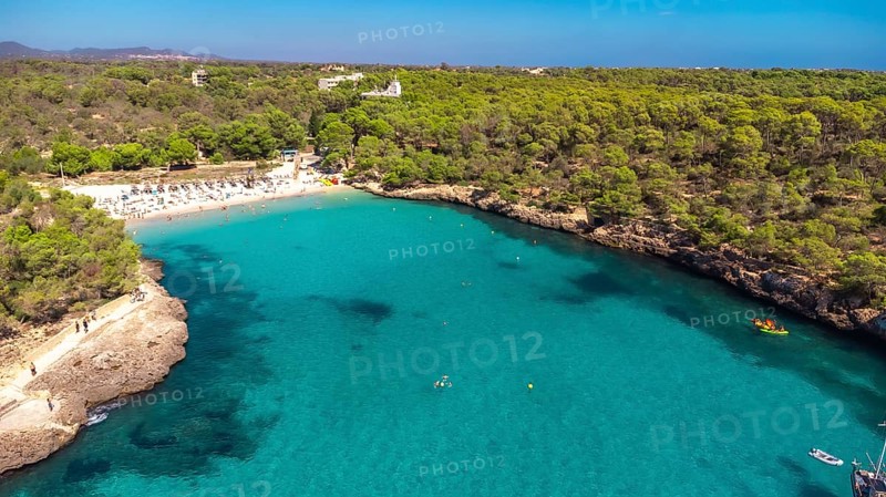 Aerial view of cala s'amarador and cala mondrago beaches in mallorca, featuring turquoise waters, lush greenery, and tourists enjoying summer activities