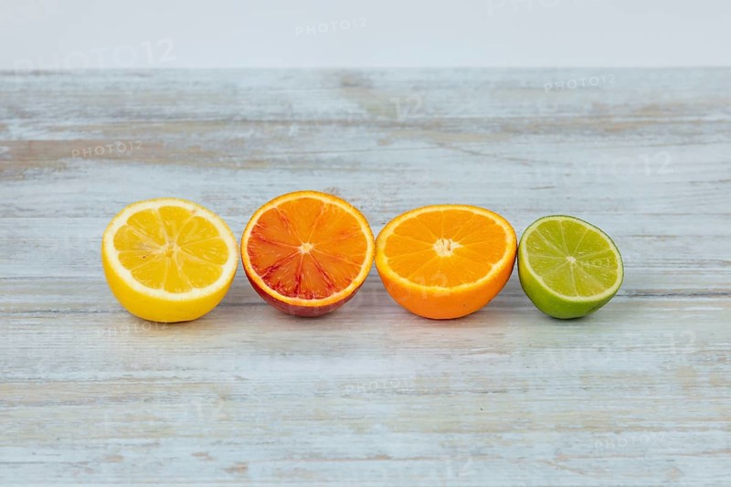 Row of half oranges, lemons and limes on a table