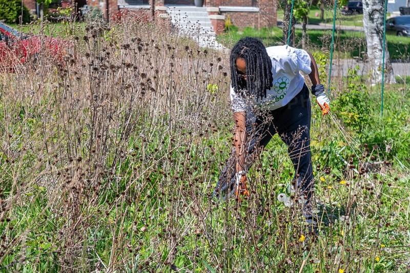 Detroit, Michigan - Volunteers do a spring cleanup in at Emerald Gardens in the Morningside neighborhood