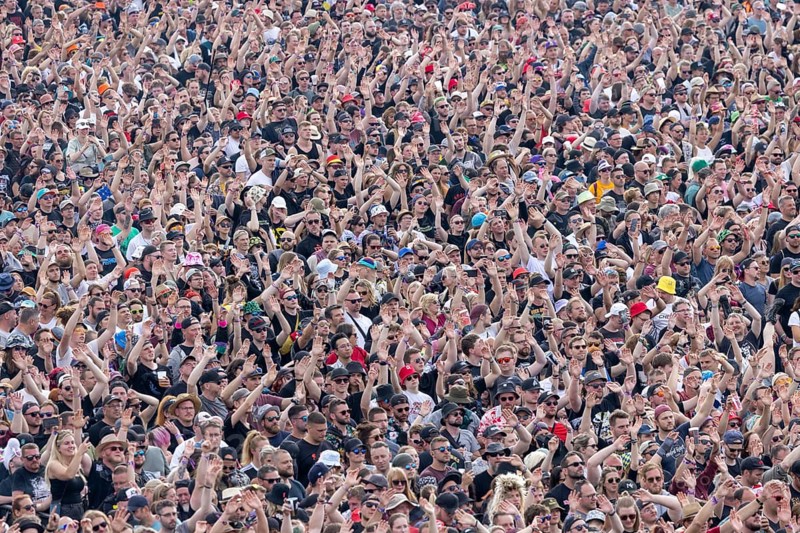 Adenau, Germany, 8 June 2024: Fans listen to the band Donots and raise their arms in the air at Rock am Ring. The festival takes place at the Nürburgring race track near the town of Adenau from 7 to 9 June 2024