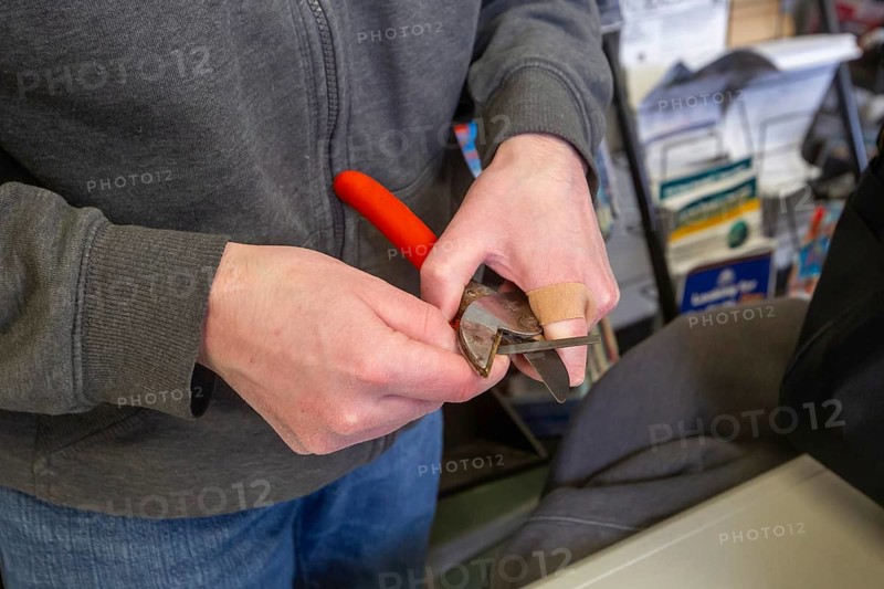 Detroit, Michigan - Volunteers repair various items during the monthly Repair Cafe at the Knapp Branch of the Detroit Public Library. Kevin Bancroft sharpens a tool. The Repair Cafe movement aims to reduce waste and save money by fixing, instead of discarding, broken items
