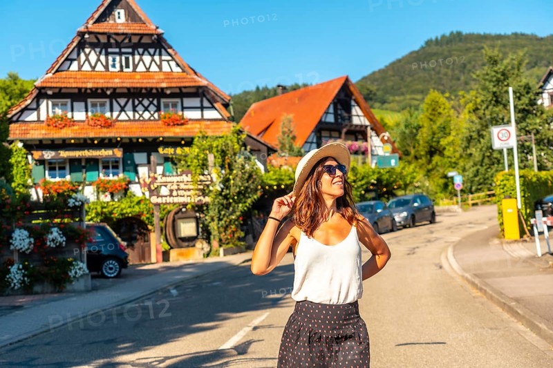 A female tourist walking through the medieval mountain village of Sasbachwalden, Black Forest, Germany