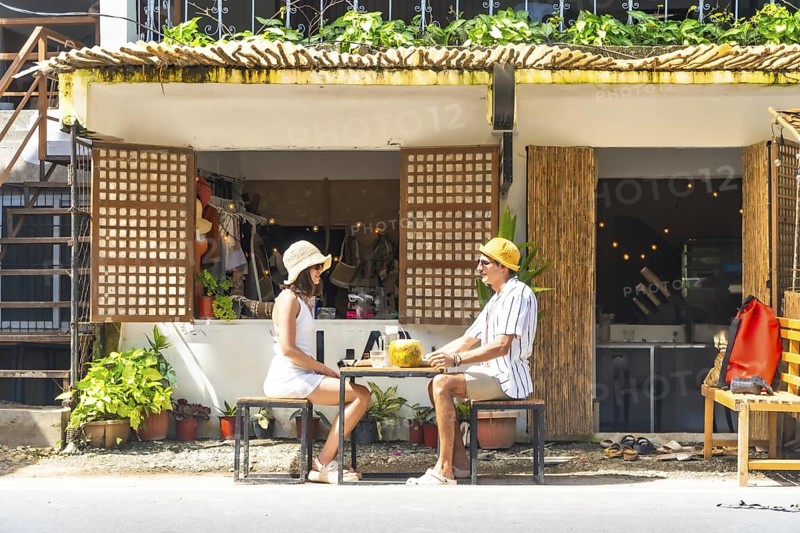 Couple relaxing at outdoor cafe, enjoying refreshing drinks during their sunny holiday in siargao island