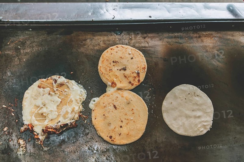 Top view of traditional pupusas on grill. Traditional grilled cheese pupusas