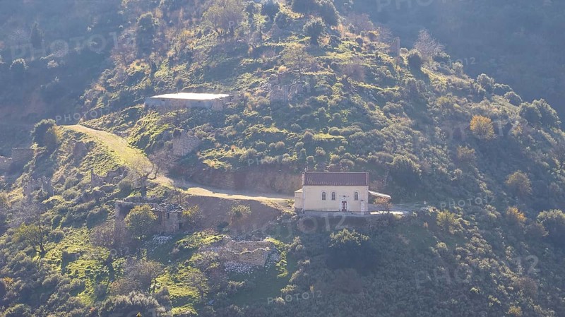 A secluded house on a sunlit hill with a dramatic mountain backdrop, Erymanthos Mountains, north-west Peloponnese peninsula, Peloponnese, Greece