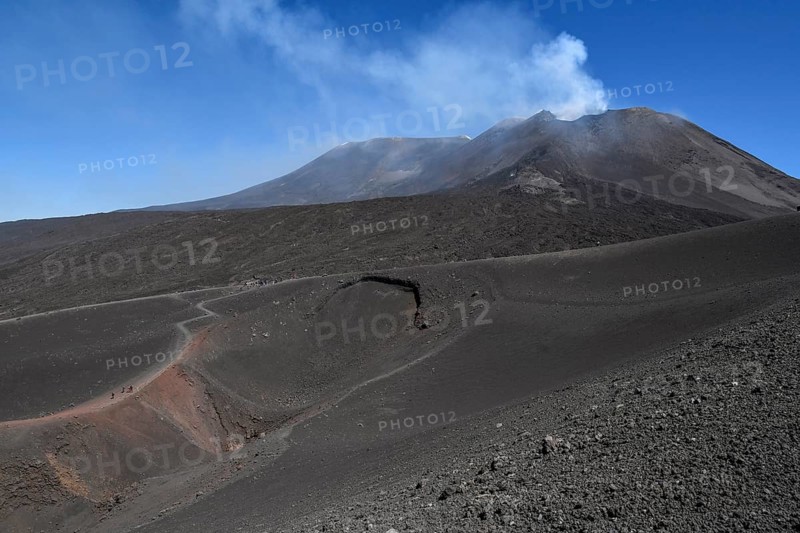 Hikers in the crater landscape of the volcano Etna, summit region, province of Catania, Sicily, Italy