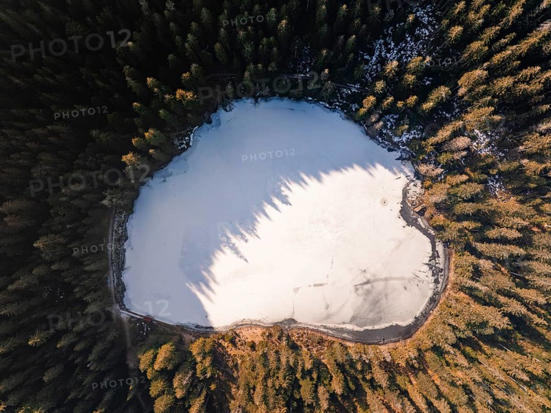 A bird's eye view of a frozen lake surrounded by forest in winter, Glaswaldsee, Bad Rippoldsau-Schapbach, Black Forest, Germany