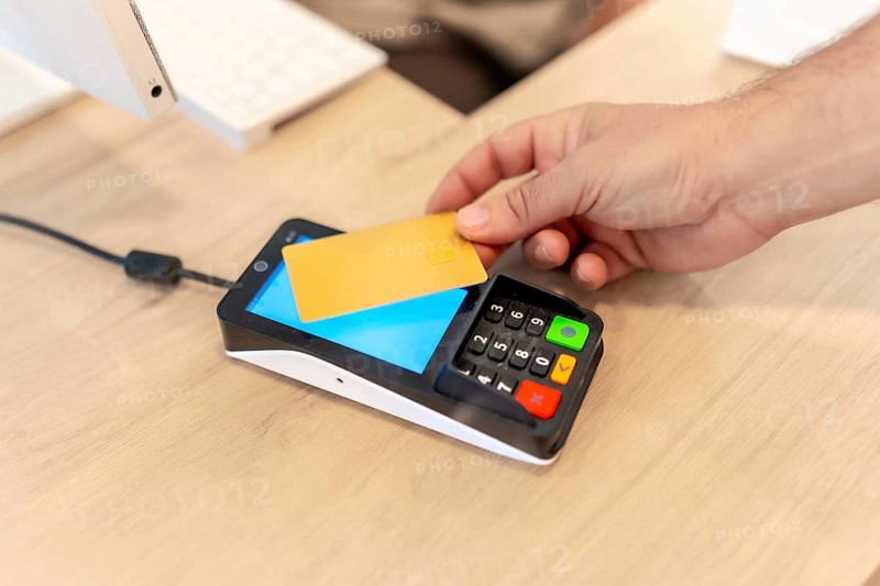 Hand of a man paying with credit card in a pharmacy store