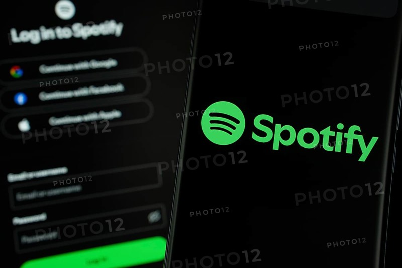 Dhaka, Bangladesh- 18 March 2025: spotify logo is displayed on a smartphone screen, with the spotify login page visible on a computer screen in the background