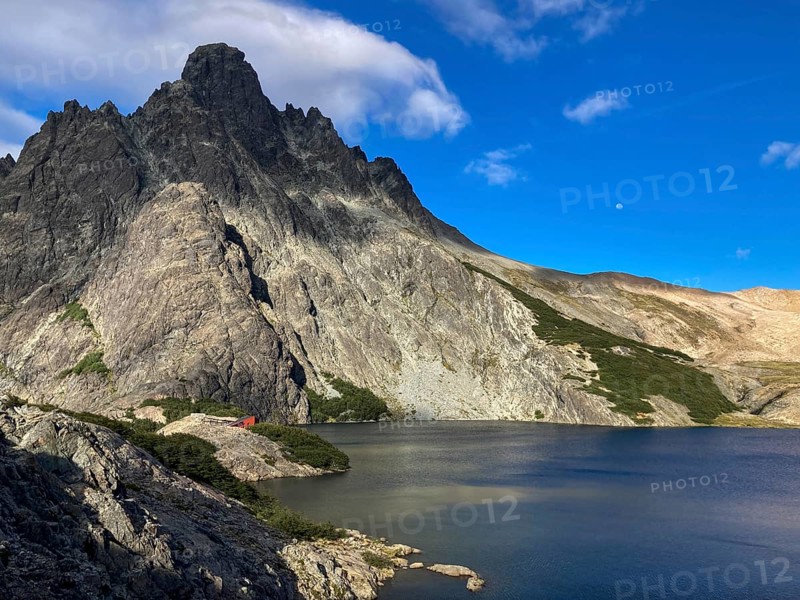 The summit of Cerro Negro with the Refugio Laguna Negra mountain hut and the mountain lake of the same name, Andes near Bariloche, Patagonia, Argentina