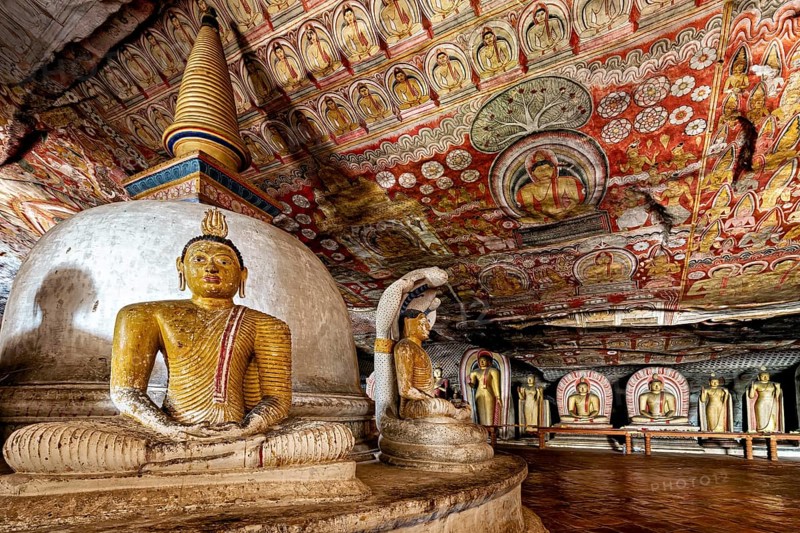 Cave interior with stupa and Buddha statues, richly decorated with ceiling paintings, The cave temple of Dambulla in Sri Lanka