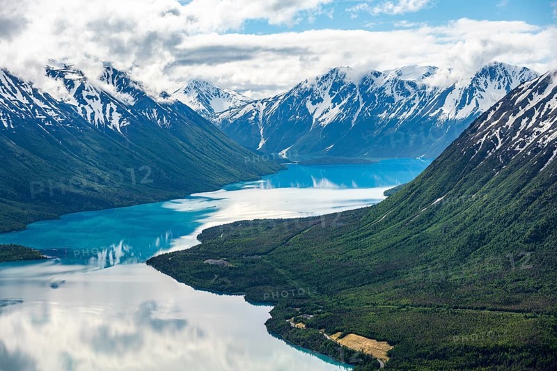 View of snowy mountains in spring and turquoise Kenai Lake with reflection, Slaughter Ridge Trail, Cooper Landing, Kenai Peninsula, Alaska, USA