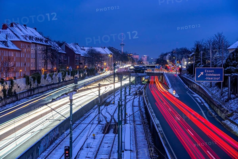 Autobahn A40, Ruhrschnellweg, near Essen at the Frohnhausen junction, evening traffic in winter, residential buildings directly on the 4-lane motorway, North Rhine-Westphalia, Germany