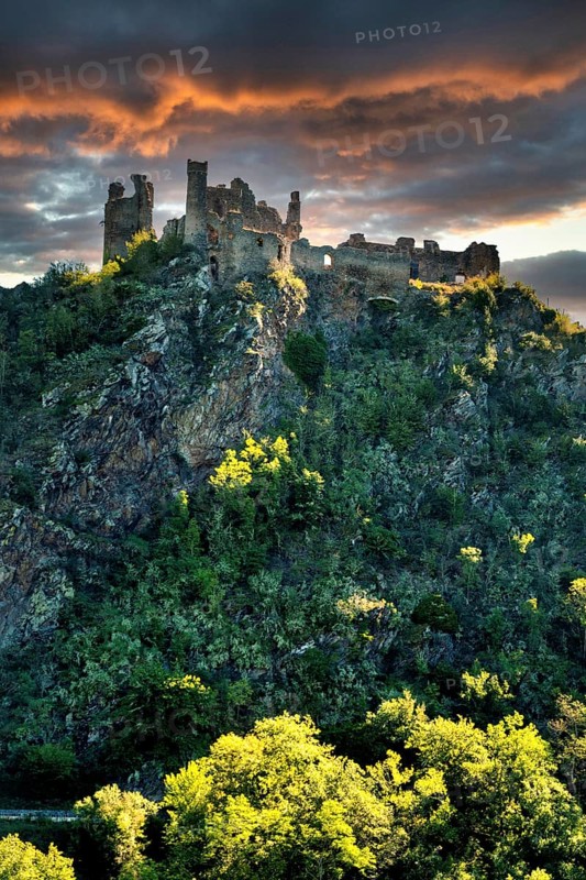 Village of Saint-Remy-de-Biot, the medieval castle in ruins of Chateau Rocher at sunset (15th century) overlooks the soul valley, Puy de Dome, Auvergne, France