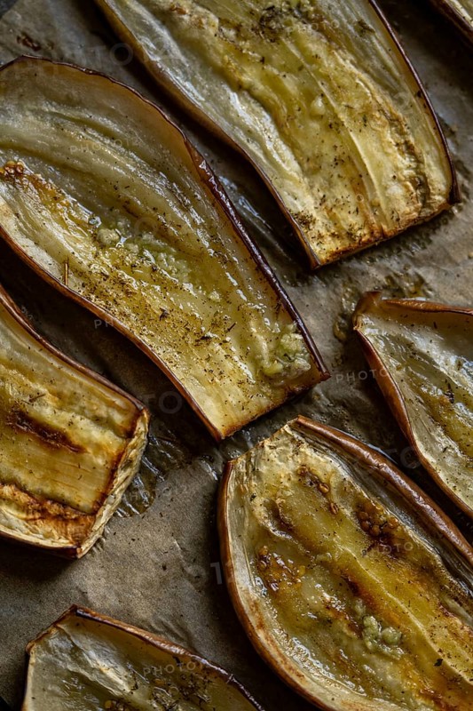 Close-up view of oven roasted eggplant slices seasoned with Mediterranean spices. Perfect for a healthy, plant-based meal or a vibrant addition to vegetarian dishes