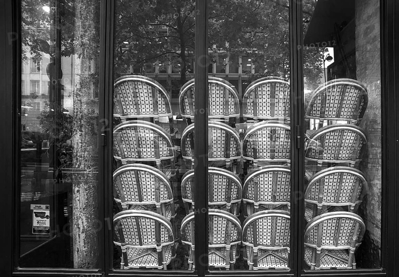 Chairs stacked in front of the window in a restaurant, black and white, Paris, France