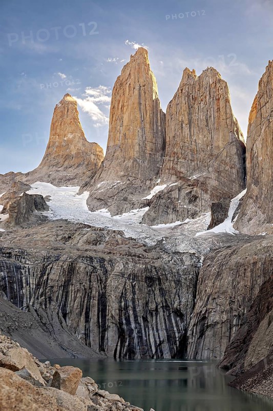 Impressive rocky towers above a clear mountain lake in the evening light, The rock towers of Torres del Paine in Patagonia Chile