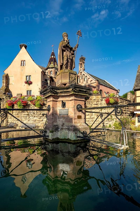 Fountain Fontaine de Saint-Léon and St Leo's Chapel in Eguisheim, Alsace, France