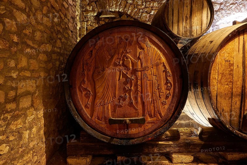 Detailed engravings on a wooden barrel in a rocky wine cellar environment, Achaia Clauss winery, Patras, Peloponnese, Greece