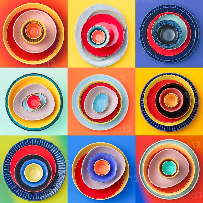 A collection of colorful ceramic dishes arranged in three by three grid. Each set is placed on a bright background, creating a striking and artistic display