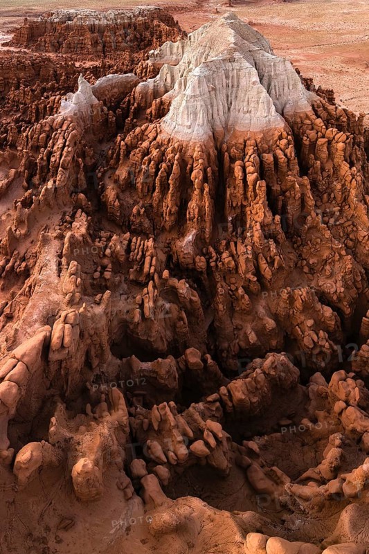 Aerial view of Goblin Valley State Park featuring intricate sandstone formations resembling goblins, set against a stark, rugged terrain in Utah, USA