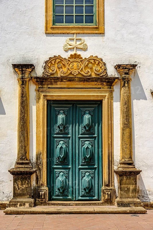 Entrance of historic baroque church with large wooden door and ornaments around in the city of Olinda, Pernambuco, Olinda, Pernambuco, Brazil