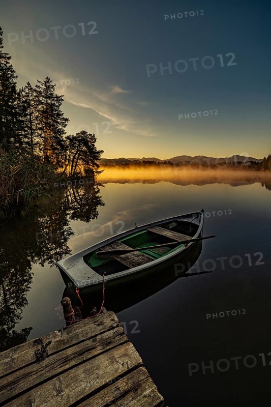 Boats in the autumnal Schmutter Weiher in the Allgäu near the municipalities of Halblech, Roßhaupten and Lechbruck in Ostallgäu in the foothills of the Alps