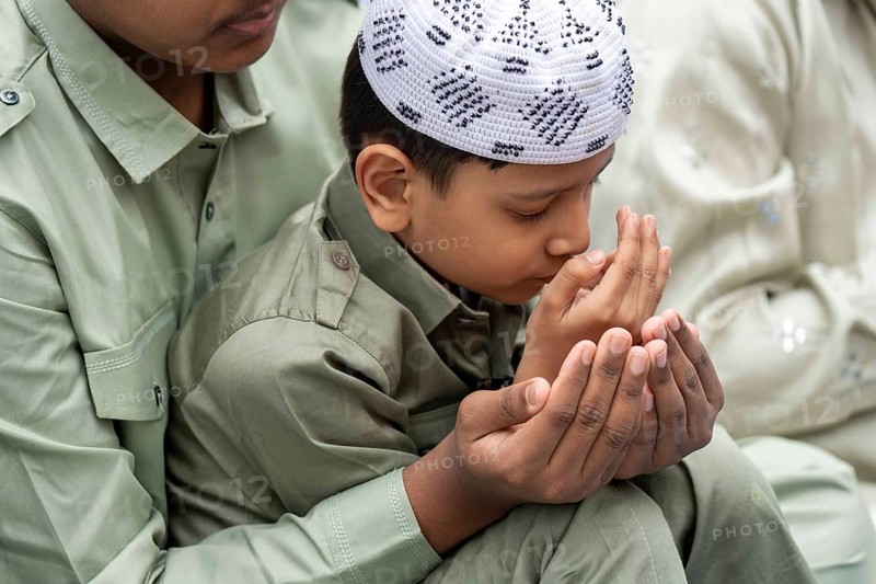 A Muslim child with elders attend to Eid al-Fitr prayer at Eidgah, on March 21, 2026 in Guwahati, India. Muslims make up a sizeable minority of India's population and celebrate Eid along with muslims across the world at the end of Ramadan