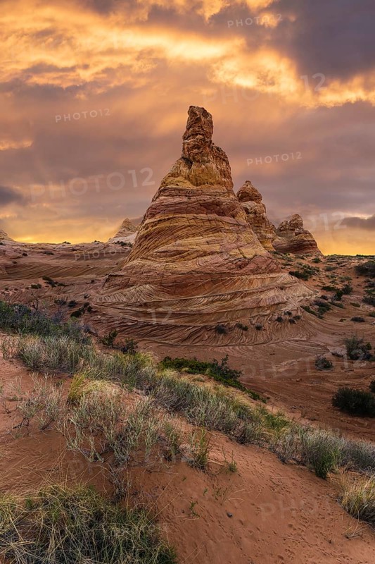 A fiery sunset illuminates the layered rock formations of Coyote Buttes in the Paria Canyon-Vermilion Cliffs Wilderness, Arizona, highlighting the vibrant desert landscape