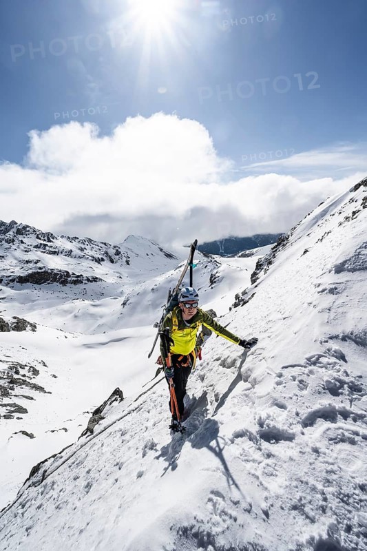 Mountaineer with skis climbing up a steep snow slope to the fork Porta d'Es-cha, ski tour Bündner Haute Route, Albula Alps, Rhaetian Alps, Grisons, Eastern Switzerland, Switzerland
