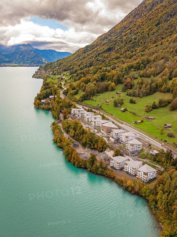 Lake with neighbouring buildings on the mountain slopes under a cloud cover, Lake Brienz. Switzerland