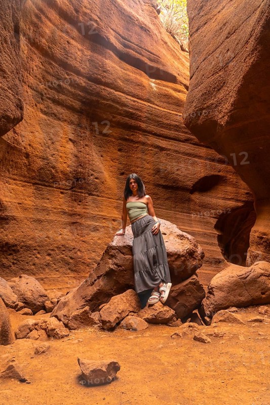 Woman standing in the magnificent barranco de las vacas canyon in gran canaria, admiring the unique rock formations and enjoying the tranquility of nature