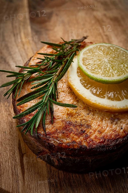 Salmon steak, fried, on a cutting board, top view, rosemary, lemon and lime, homemade, one serving, no people
