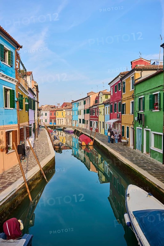 Colorful houses beside the waterway in between 'Fondamenta Pontinello Sinistra' and 'Fondamenta Pontinello Destra' from 'love viewing bridge' with boats lying in the water on the island of Burano, Italy
