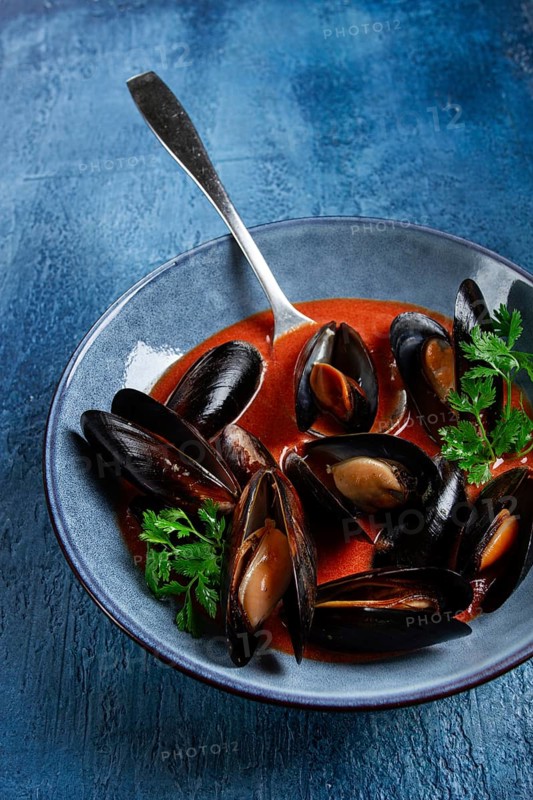 Fra Diavolo mussels, mussels in tomato sauce, Italian dish, on a blue background, homemade, no people