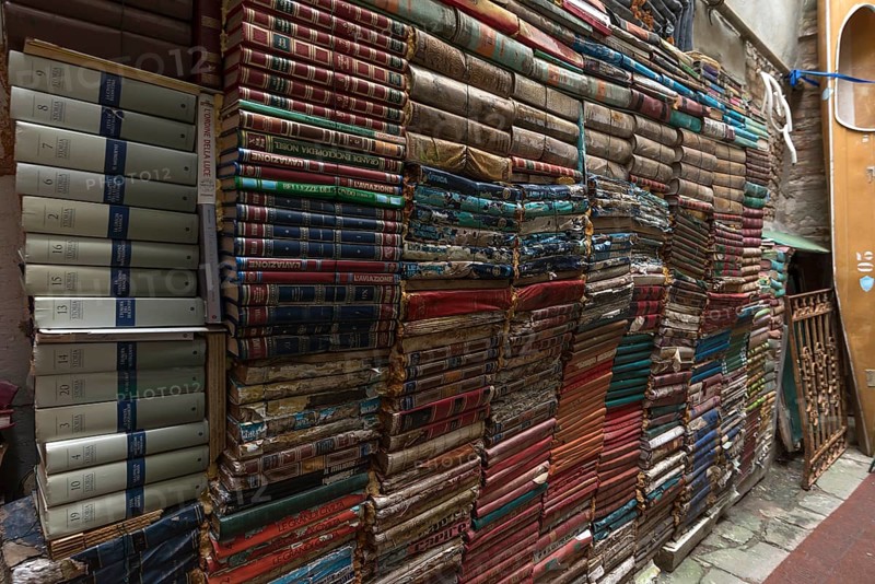 Stacked books on a wall after flood damage in a bookstore, Venice, Veneto, Italy