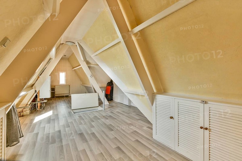 An inviting modern A-frame interior featuring wooden beams and a spacious layout. The aesthetic showcases a stylish blend of simplicity and functionality