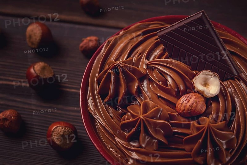 Chocolate nut paste, mousse, pasta, in a cup, on a wooden table, top view, selective focus, no people