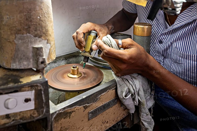 Grinding machine in operation, with hands using tools for precise work, The gemstone cutters in the city of Ratnapura in Sri Lanka