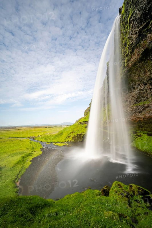 Seljalandsfoss waterfall with rainbow, long exposure, Seljalandsa river, South Iceland, Iceland