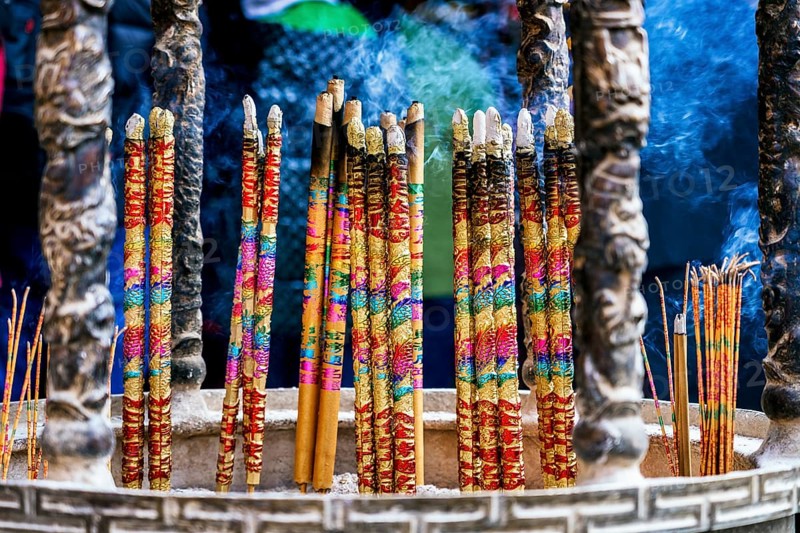 Colorful incense sticks enveloped in smoke at a Taoist and Chinese Buddhist temple in Macau, symbolizing prayers and offerings to deities