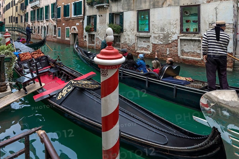 Gondola ride with tourists through the old town of Venice, Veneto, Italy