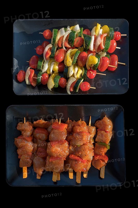 Meat and vegetable skewers in bowls on a black background, Bavaria, Germany