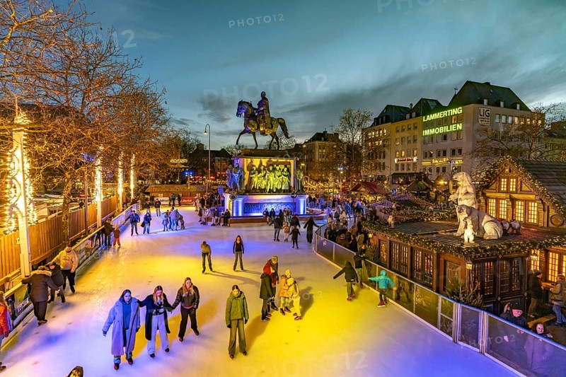 Christmas market Heinzel's winter fairy tale with the ice rink at Heumarkt and the equestrian monument to King Frederick William III of Prussia at dusk, Cologne, North Rhine-Westphalia, Germany