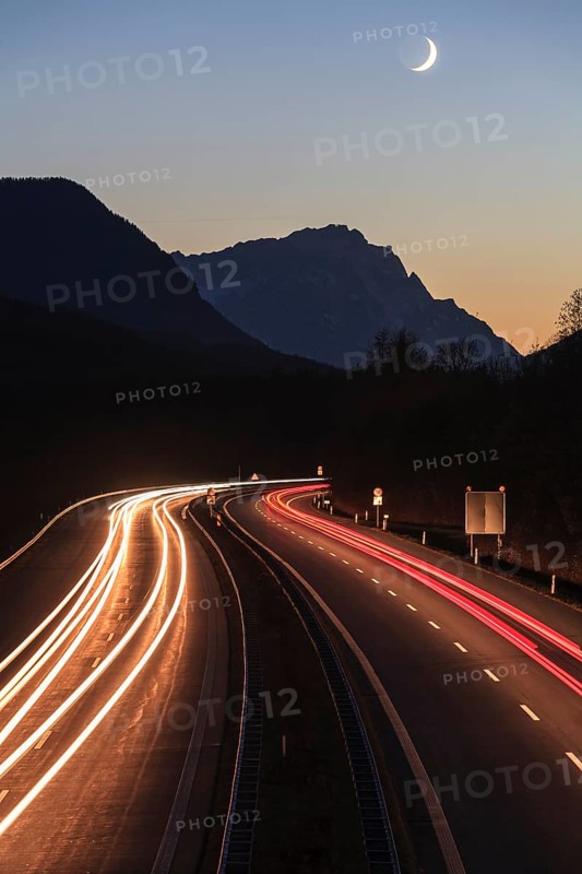 Night shot of a motorway, long exposure, moon, twilight, traffic, car lights, A 95, behind it Zugspitze, Bavaria, Germany